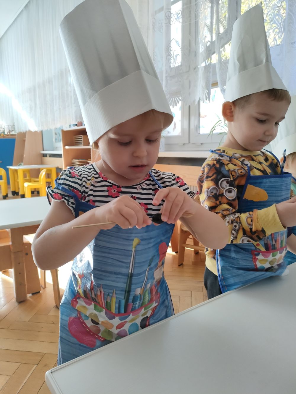 Chłopiec i dziewczynka robią owocowe szaszłyki.