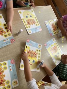 Dzieci wykonują pracę plastyczną, ozdabianie kropki