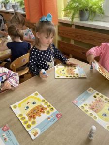 Dzieci wykonują pracę plastyczną, ozdabianie kropki