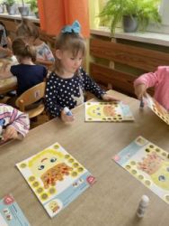 Dzieci wykonują pracę plastyczną, ozdabianie kropki