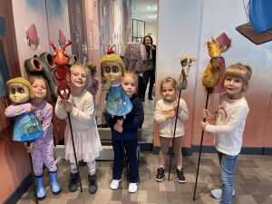 5 dziewczynek stoi i trzyma różne kukiełki