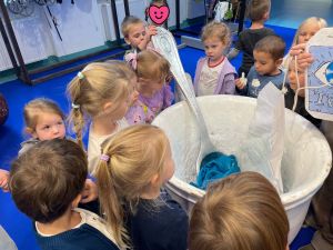 Dzieci stoją przy wielkiej filiżance- rekwizycie teatralnym