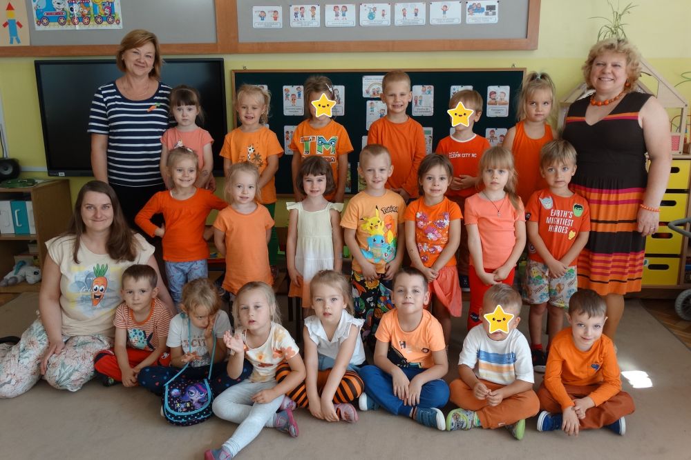 Zdjęcie grupowe grupy 3 z okazji dnia marchewki. Dzieci ubrane są na pomarańczowo