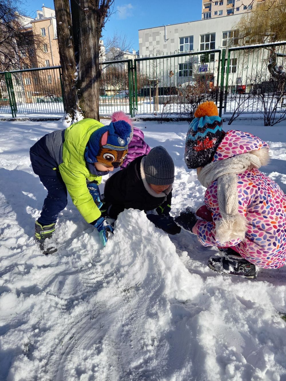 Dzieci lepią bałwana ze śniegu