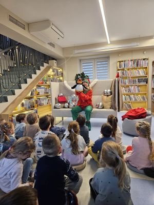 Na kanapie siedzi Pani w stroju Elfa i trzyma pacynkę pingwina