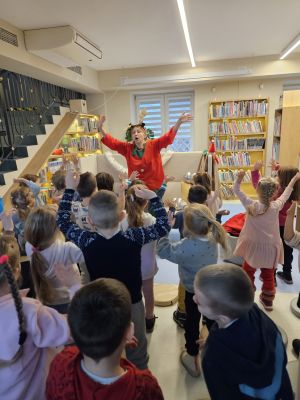 Pani w stroju Elfa stoi i pokazuje ruch, a dzieci naśladują po niej ruchy