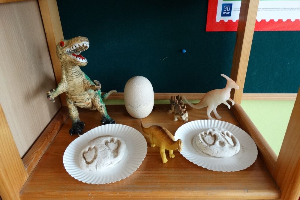 Kącik tematyczny dinozaury- figurki dinozaurów i odciski łap dinozaurów w masie solnej