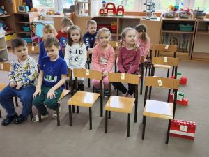 Krzesełka ustawione są w 3 rzędach. Dzieci siedzą na części z tych krzeseł