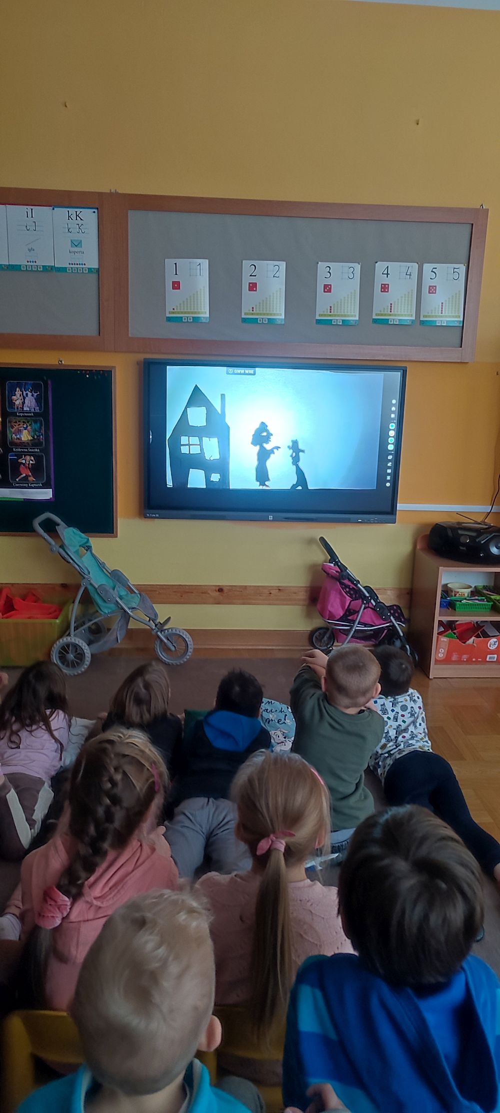 Dzieci oglądają teatr cieni na tablicy multimedialnej
