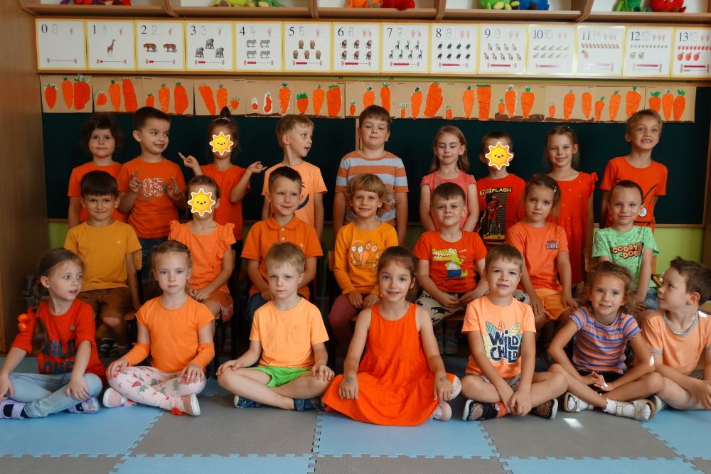 Zdjęcie grupowe dzieci ubranych na pomarańczowo