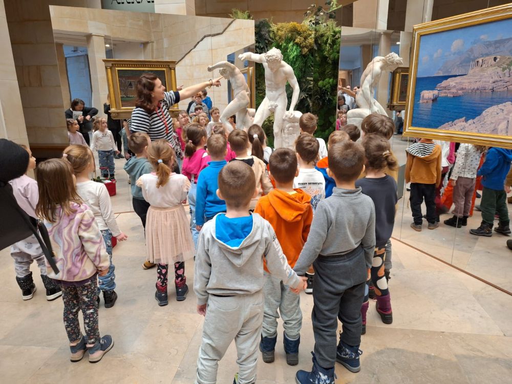 dzieci stoją w muzeum i patrzą na rzeźby w muzeum