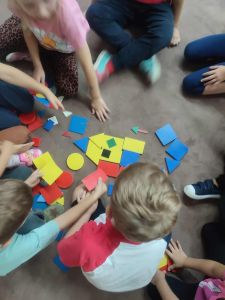 Dzieci podzielone na grupy, tworzą obrazek z klocków Dienesa