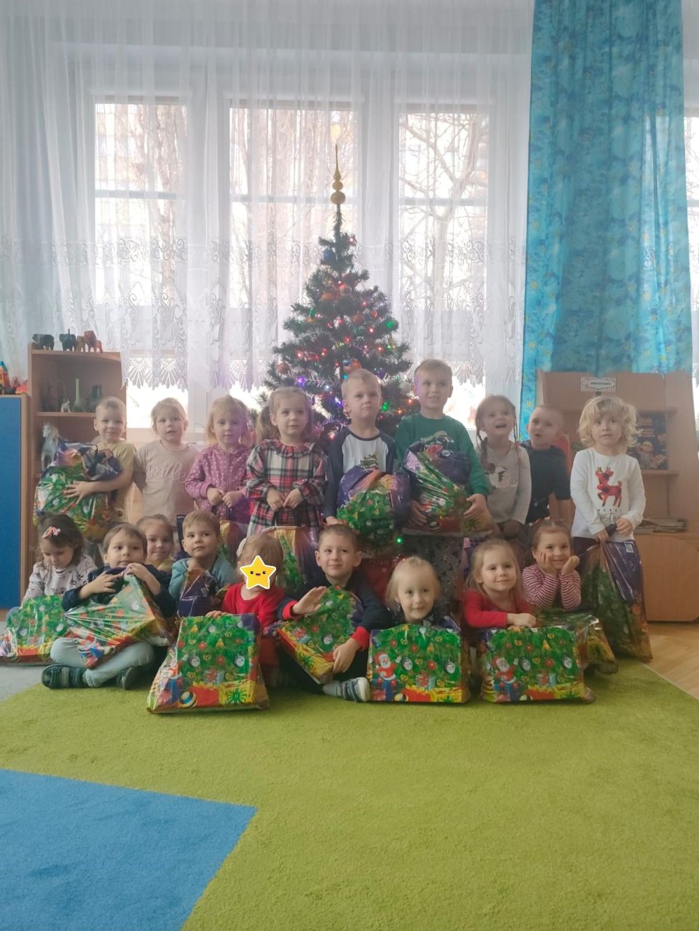 Zdjęcie grupowe dzieci przed choinką z prezentami