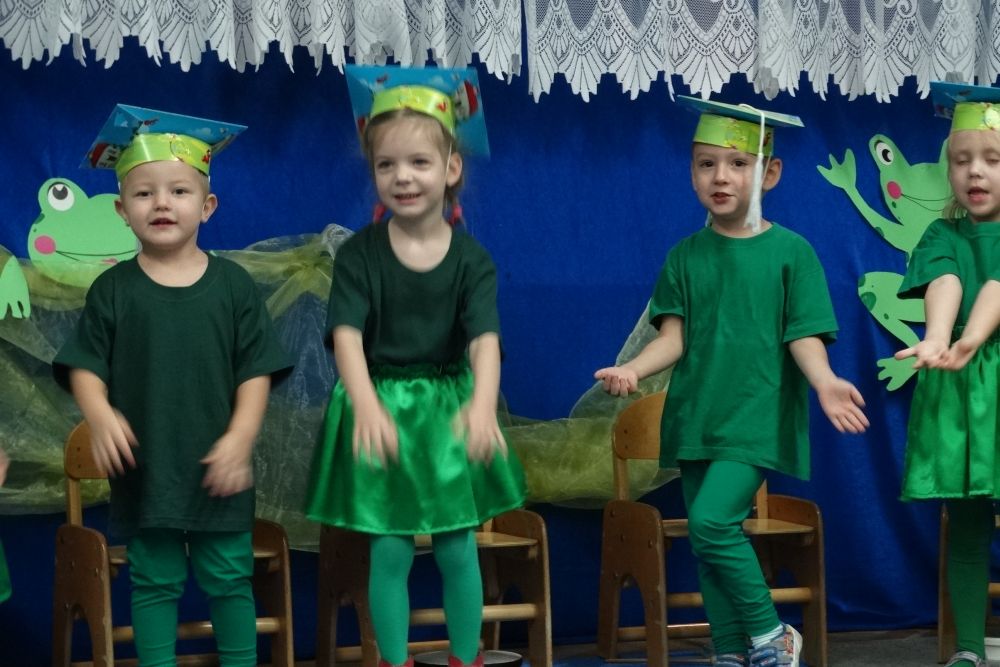 Dzieci w strojach żabek pokazują do piosenki