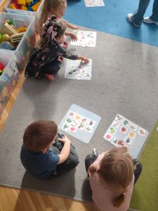 Dzieci układają obrazki z warzywami na podkładce przed sobą