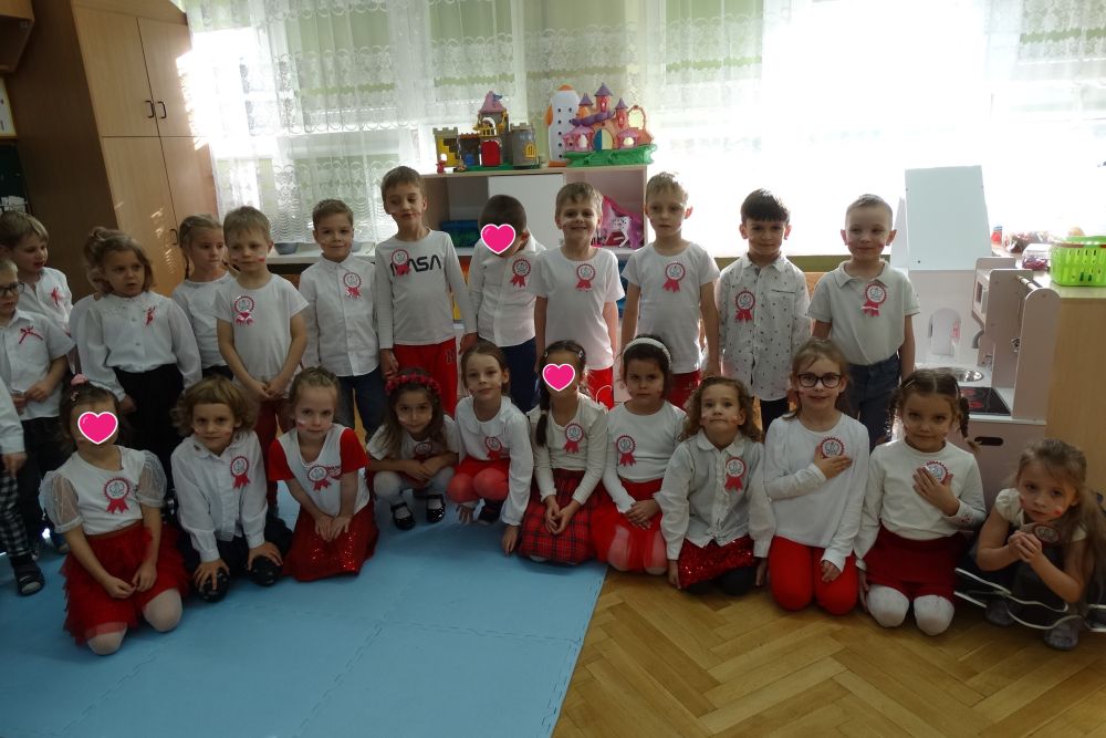 Dzieci z gr 5 i 4 pozują do zdjęcia w eleganckich biało czerwonych ubraniach