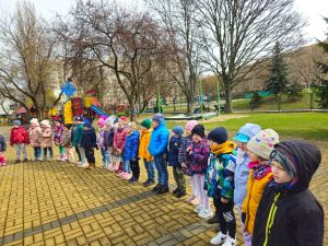 zdjęcie dzieci stojących na przedszkolnym placu zabaw
