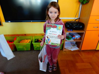 Dziewczynka z gr 4 pokazuje dyplom i nagrodę