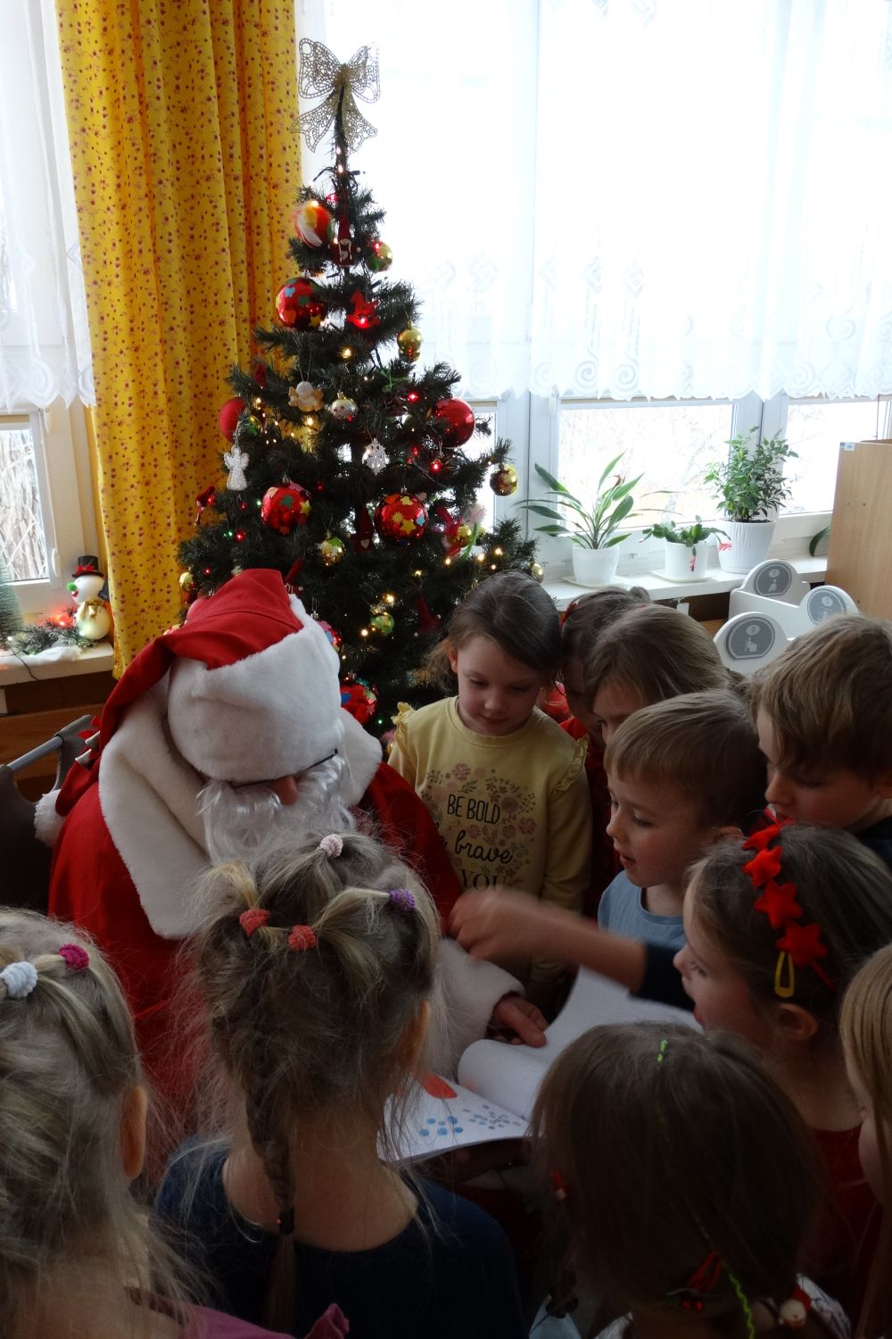 Dzieci z grupy 4 pokazują św. Mikołajowi własnoręcznie zrobioną książeczkę, którą podarowały Mikołajowi z okazji Jego imienin.