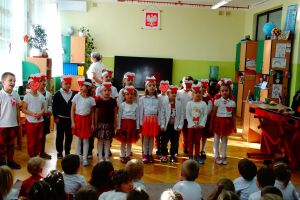Dzieci z grupy 4 stoją i śpiewają pieśń Legiony