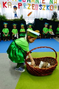 Dziewczynka bierze przytulankę z wielkiego kosza stojącego na dywanie