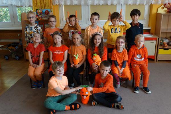 Dzieci ubrane na pomarańczowo z marchewkami