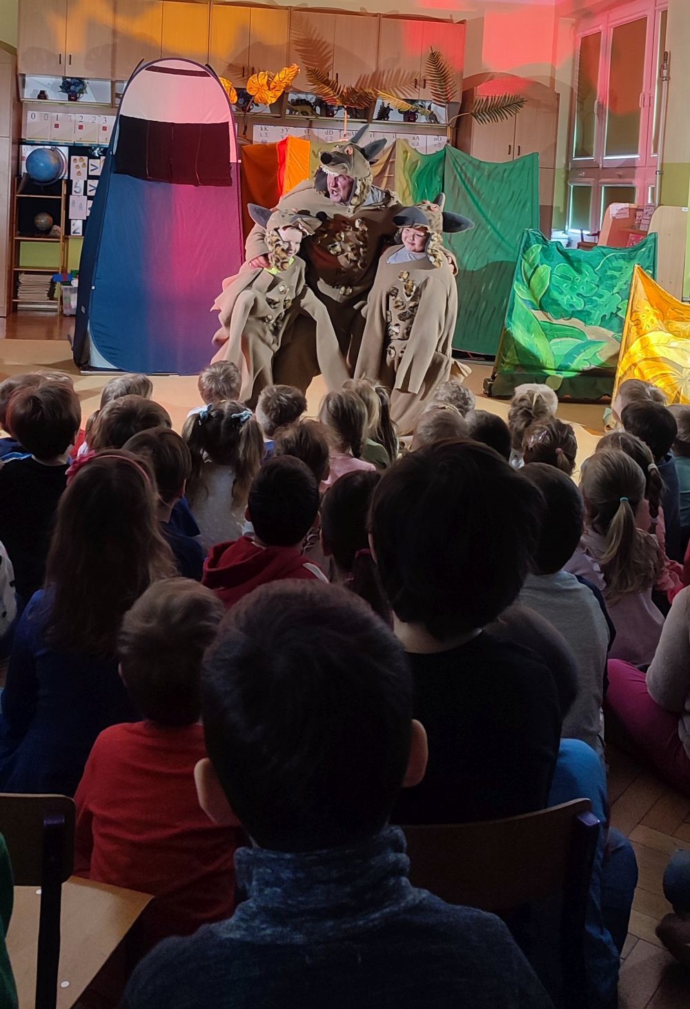 Przedstawienie Lwi król, aktor i dwoje dzieci w stroju hien