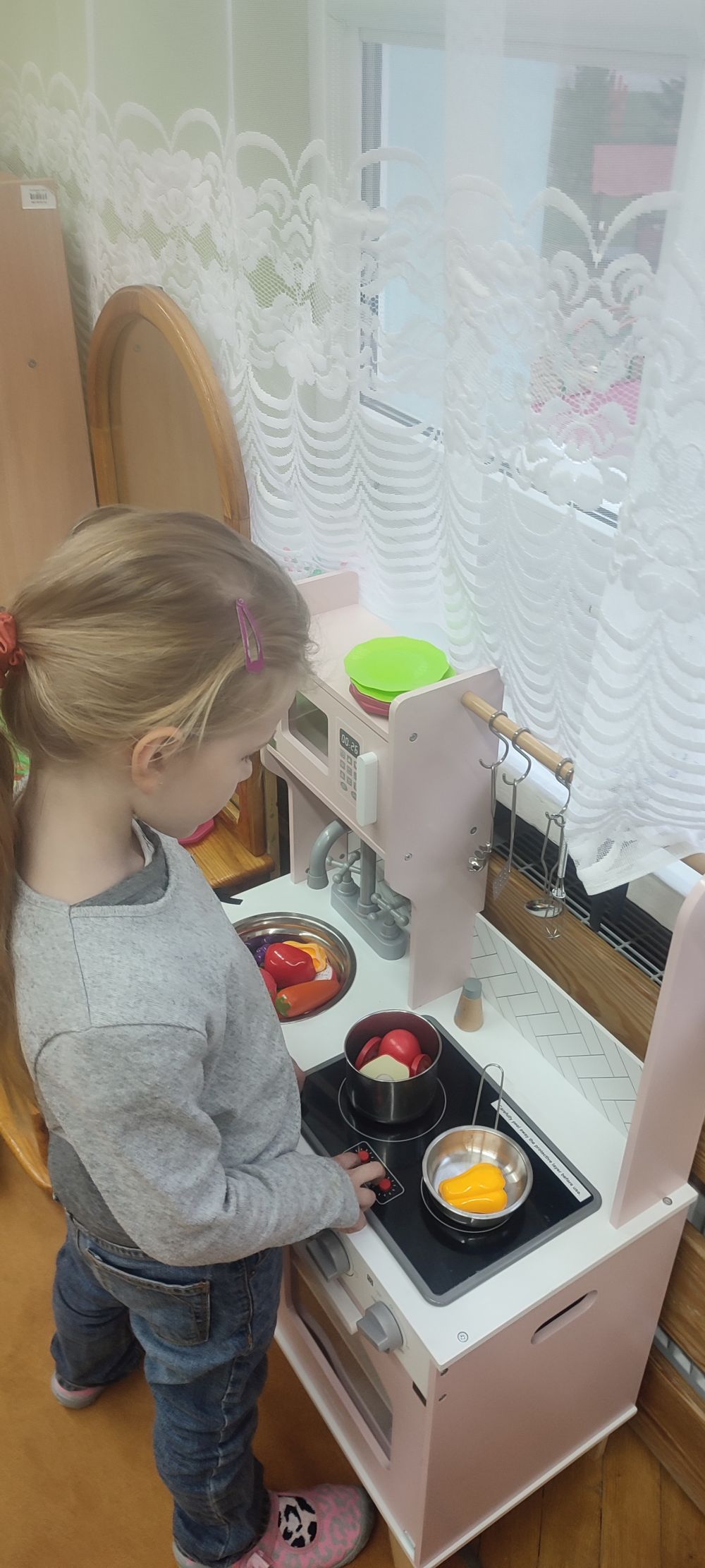 Dziewczynka bawi się w kąciku kucharskim