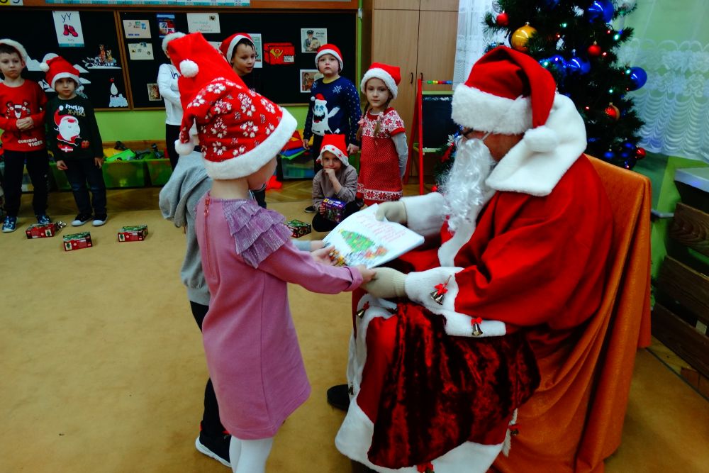 Dzieci dają prezent Mikołajowi