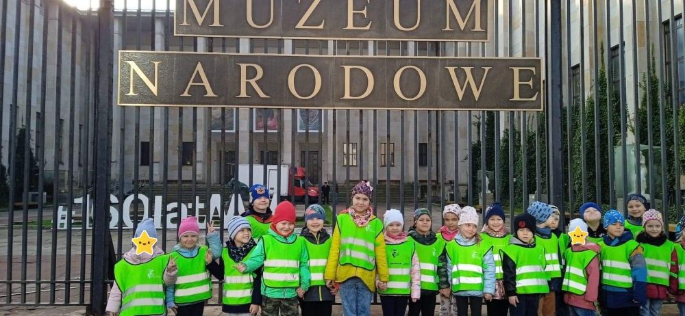 Dzieci z grupy 4 stoją na tle Muzeum Narodowego w Warszawie