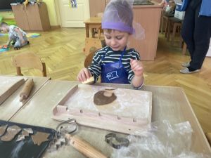 Chłopiec wykrawa z ciasta pierniczki