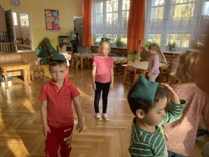 Dzieci chodzą z woreczkami gimnastycznymi na głowach