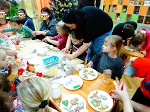 Dzieci ze swoimi rodzicami dekorują pierniczki