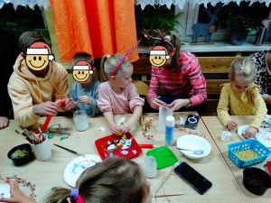 Dzieci ze swoimi rodzicami dekorują pierniczki