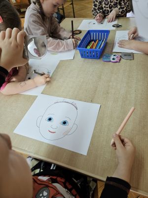 Chłopiec patrzy w lusterko i rysuje swój portret