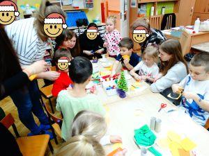 Rodzice z dziećmi robią świąteczne choinki