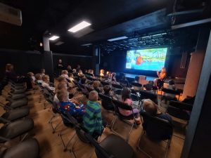 Dzieci siedzą na widowni i oglądają film