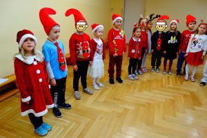Dzieci stoją w półkolu i śpiewają Mikołajowi piosenkę