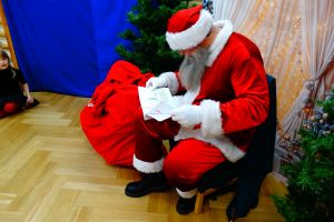 Święty Mikołaj czyta książeczkę od dzieci