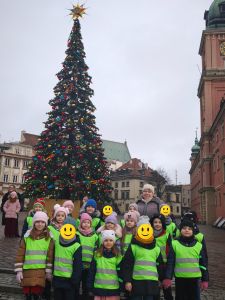 Zdjęcie grupowe dzieci z nauczycielką przy choince na starym mieście