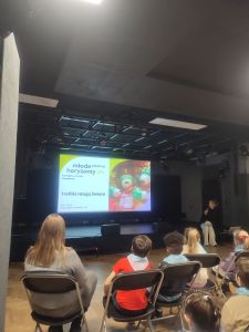 Dzieci siedzą na Krzesłach i Oglądają Bajkę Trefliki na dużym ekranie kinowym