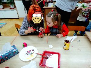 Dzieci ze swoimi rodzicami ozdabiają bombki