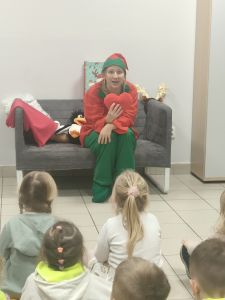 Na kanapie siedzi Pani w stroju Elfa i w ręce trzyma pluszowe serce