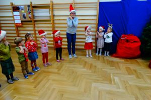 Dzieci stoją w półkolu i śpiewają piosenkę dla świętego Mikołaja