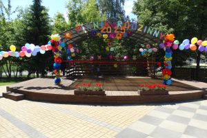 Na zdjęciu przedszkolny amfiteatr ozdobiony balonami i kwiatami i napisem Piknik Rodzinny 2025. 