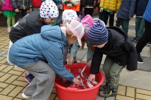 Dzieci topią marzannę w misce z wodą